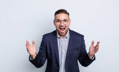 Genç yakışıklı adam kendini mutlu hissediyor ve inanılmaz bir şeye hayret ediyor. İş adamı konsepti