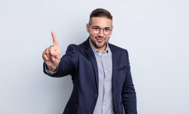 Genç yakışıklı adam gururla gülümsüyor ve kendinden emin bir numara oluyor. İş adamı konsepti