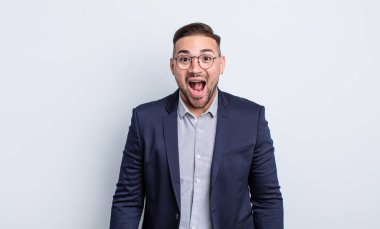 Genç yakışıklı adam mutlu ve hoş bir şekilde şaşırmış görünüyor. İş adamı konsepti