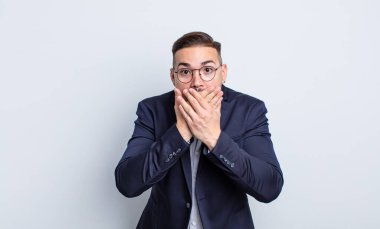 Genç ve yakışıklı bir adam elleri ile ağzını kapatıyor ve şok geçiriyor. İş adamı konsepti