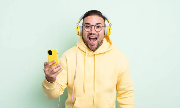 Young Handsome Man Looking Happy Pleasantly Surprised Headphones Smartphone Concept — Stock Photo, Image