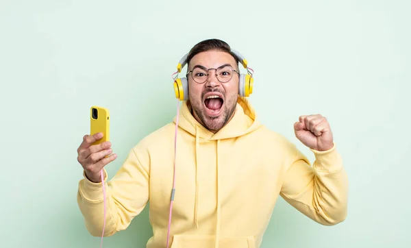 Young Handsome Man Shouting Aggressively Angry Expression Headphones Smartphone Concept — Stock Photo, Image