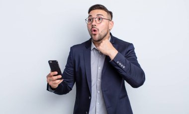 Genç yakışıklı adam stresli, endişeli, yorgun ve hayal kırıklığına uğramış iş ve akıllı telefon kavramı