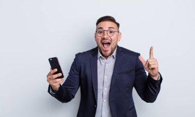 Genç yakışıklı bir adam, bir fikir işi ve akıllı telefon kavramını fark ettikten sonra mutlu ve heyecanlı bir dahi gibi hissediyor.