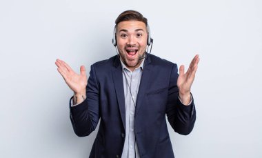 Genç yakışıklı adam kendini mutlu hissediyor ve inanılmaz bir şeye hayret ediyor. Tele pazarlamacı kavramı