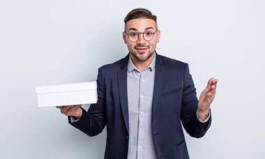 Genç yakışıklı adam kendini mutlu hissediyor ve inanılmaz bir şeye hayret ediyor. beyaz kutu kavramı