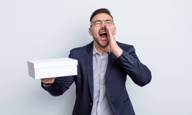 Genç yakışıklı adam mutlu hissediyor, elleri ağzının kenarında bağırıyor. beyaz kutu kavramı