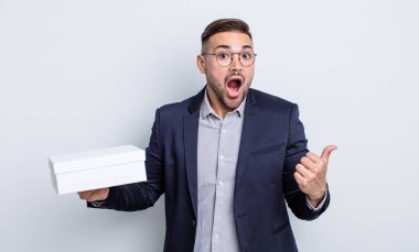 İnanamadığı için şaşırmış genç ve yakışıklı bir adam. beyaz kutu kavramı