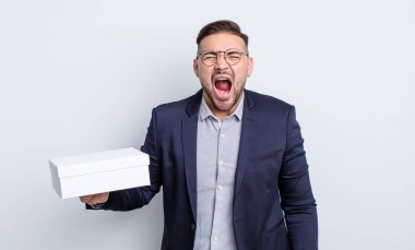 Genç yakışıklı adam agresif bir şekilde bağırıyor, çok kızgın görünüyor. beyaz kutu kavramı