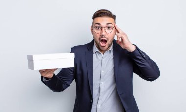 Genç yakışıklı adam şaşırmış görünüyor, yeni bir düşünce, fikir ya da konsept fark ediyor. beyaz kutu kavramı