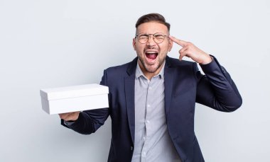 Genç yakışıklı adam mutsuz ve stresli görünüyor, intihar jesti silah işareti yapıyor. beyaz kutu kavramı