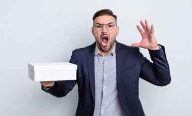 Genç yakışıklı adam ellerini havaya kaldırarak çığlık atıyor. beyaz kutu kavramı