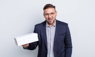 Genç yakışıklı adam şaşkın ve şaşkın hissediyor. beyaz kutu kavramı