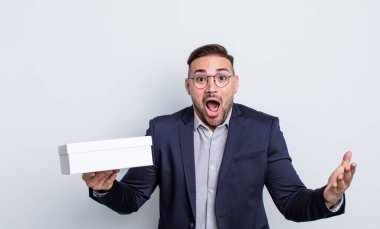 Genç ve yakışıklı bir adam şok olmuş ve şaşırmış hissediyor. beyaz kutu kavramı