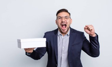 Genç yakışıklı adam sinirli bir ifadeyle agresif bir şekilde bağırıyor. beyaz kutu kavramı