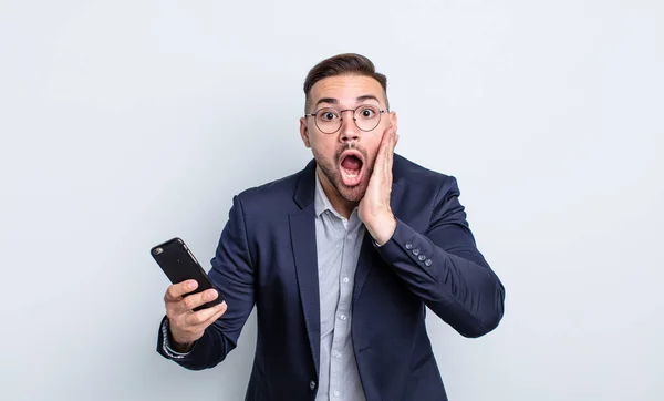 Mladý Pohledný Muž Pocit Šoku Strach Podnikání Smartphone Koncept — Stock fotografie
