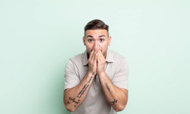 Genç yakışıklı adam endişeli, üzgün ve korkmuş, elleri ağızda, endişeli ve berbat görünüyor.