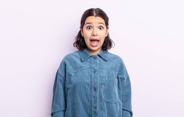 Güzel genç bir kadın şok olmuş ya da şaşırmış görünüyor, ağzı açık bir şekilde 