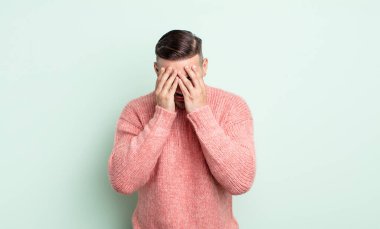 Genç yakışıklı adam üzgün, hayal kırıklığına uğramış bir bakışla gözlerini kapatıyor umutsuzluk, ağlama, yan bakış