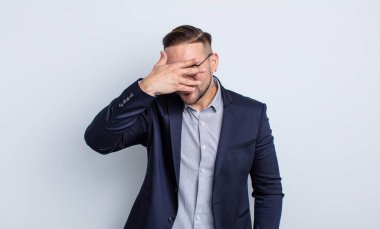 Genç, yakışıklı adam şok olmuş, korkmuş ya da korkmuş görünüyor. İş adamı konsepti