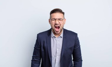 Genç yakışıklı adam agresif bir şekilde bağırıyor, çok kızgın görünüyor. İş adamı konsepti