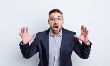 Genç yakışıklı adam ellerini havaya kaldırarak çığlık atıyor. İş adamı konsepti