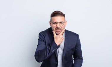 Ağzı ve gözleri açık ve eli çenesinde genç yakışıklı bir adam. İş adamı konsepti