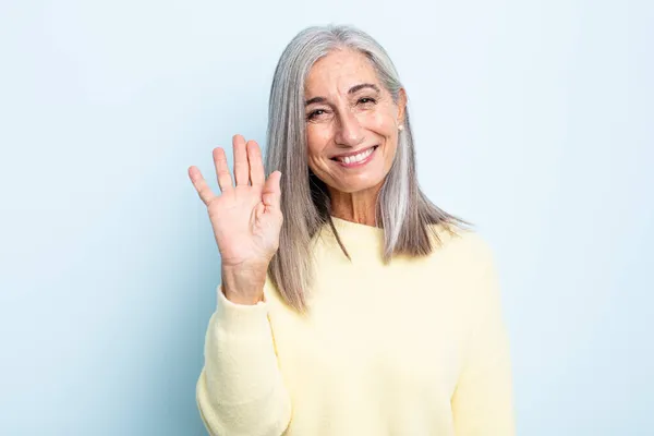 中世灰色の髪の女性は喜んで陽気に笑って手を振って歓迎し挨拶したりさよならを言う — ストック写真