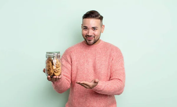 若いハンサムな男は陽気に笑って幸せを感じコンセプトを示す クッキーボトルのコンセプト — ストック写真