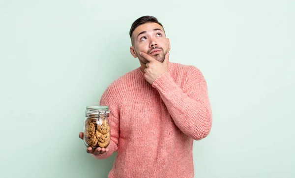 Joven Hombre Guapo Pensando Sintiéndose Dudoso Confundido Concepto Botella Cookies — Foto de Stock