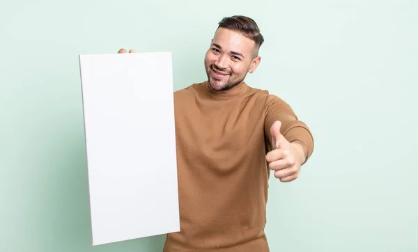 Young Handsome Man Feeling Proud Smiling Positively Thumbs Empty Canvas — Stock Photo, Image