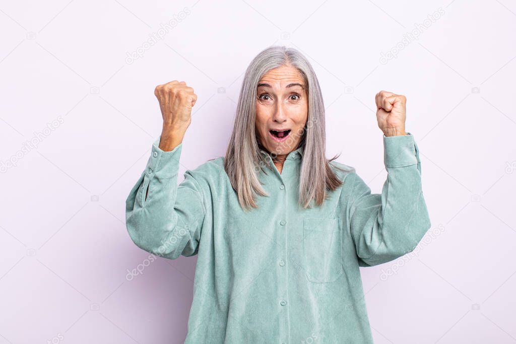 middle age gray hair woman celebrating an unbelievable success like a winner, looking excited and happy saying take that!