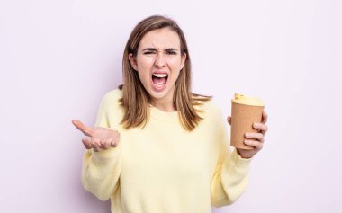 Genç ve güzel bir kadın sinirli, sinirli ve sinirli görünüyor. kahve konseptini kaldır.