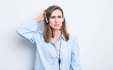 Genç, güzel bir kadın kafası karışmış, kafası karışmış, kaşınıyor. tele pazarlamacı kavramı