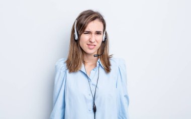 Genç, güzel bir kadın kafası karışmış ve şaşkın görünüyor. tele pazarlamacı kavramı