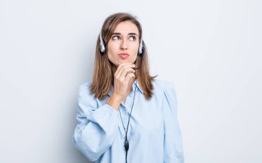 Genç, güzel bir kadın düşünüyor, kuşkulu ve şaşkın hissediyor. tele pazarlamacı kavramı