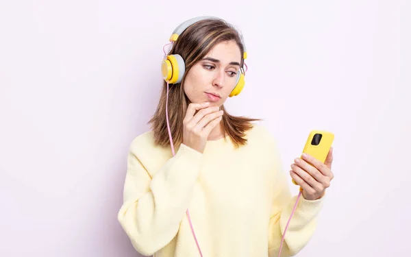 Fiatal Csinos Gondolkodik Kétkedő Zavarodott Fejhallgató Telefon Koncepció — Stock Fotó