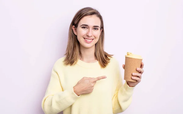 年轻漂亮的女人兴高采烈地微笑着 感到快乐 指指点着身边 去掉咖啡的概念 — 图库照片