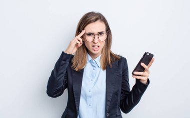 Genç ve güzel bir kadın kafası karışık ve şaşkın hissediyor, deli olduğunu gösteriyor. iş kavramı