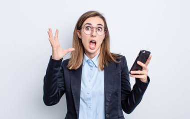 Genç ve güzel bir kadın ellerini havaya kaldırarak çığlık atıyor. iş kavramı