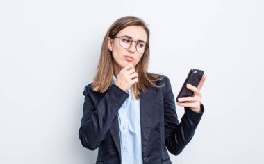 Genç, güzel bir kadın düşünüyor, kuşkulu ve şaşkın hissediyor. iş kavramı