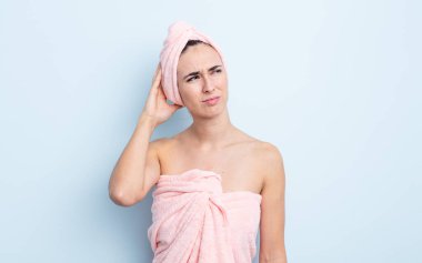 Genç, güzel bir kadın kafası karışmış, kafası karışmış, kaşınıyor. güzellik ve duş konsepti