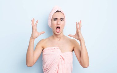 Genç ve güzel bir kadın ellerini havaya kaldırarak çığlık atıyor. güzellik ve duş konsepti