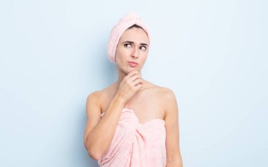 Genç, güzel bir kadın düşünüyor, kuşkulu ve şaşkın hissediyor. güzellik ve duş konsepti