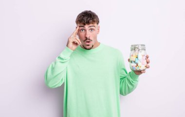 Genç yakışıklı adam şaşırmış görünüyor, yeni bir düşünce, fikir ya da konsept fark ediyor. jöle şekeri konsepti