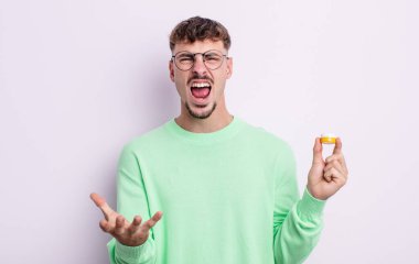 Genç ve yakışıklı bir adam sinirli, sinirli ve sinirli görünüyor. kontakt lensler