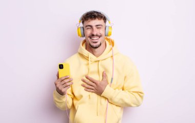 Genç yakışıklı bir adam komik bir şakaya yüksek sesle gülüyor. müzik konsepti