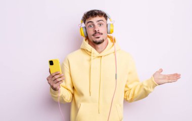 Genç yakışıklı adam şaşkın, şaşkın ve şüpheci hissediyor. müzik konsepti