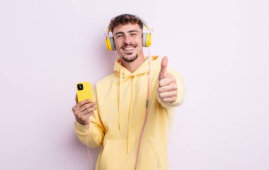 Genç ve yakışıklı bir adam gururlu, olumlu gülümsüyor. müzik konsepti