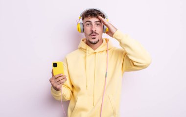 Genç yakışıklı adam mutlu, şaşkın ve şaşırmış görünüyor. müzik konsepti